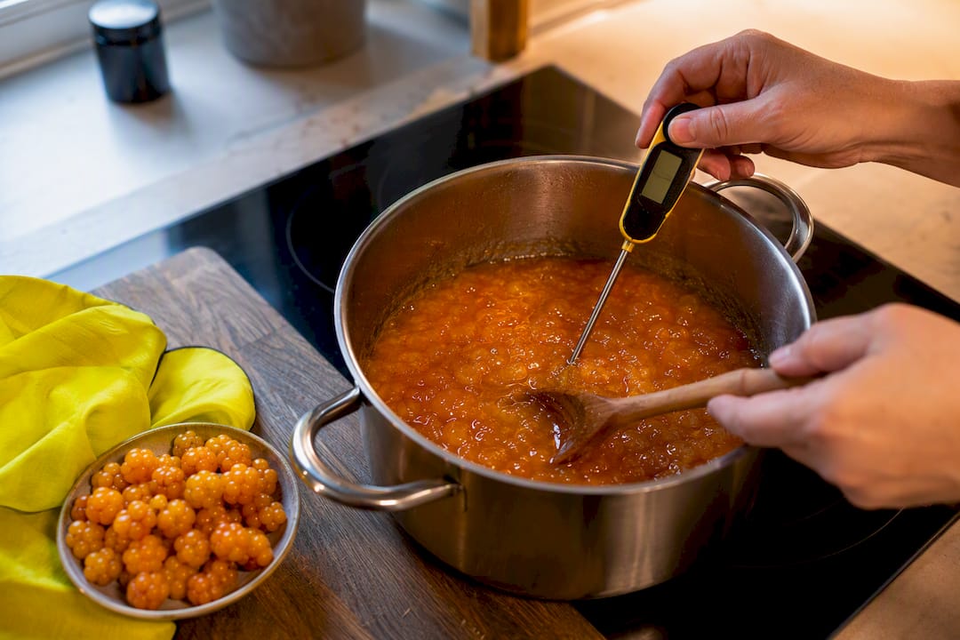 Cloudberry jam being checked while cooking