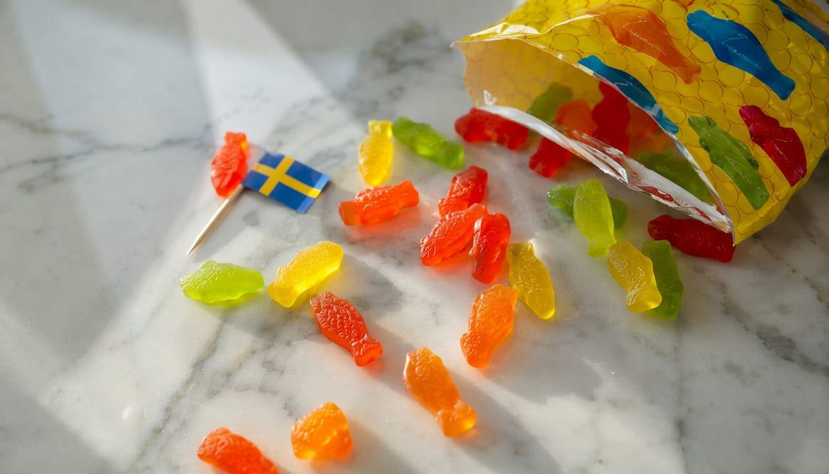 Scattered Swedish Fish candies with Swedish flag