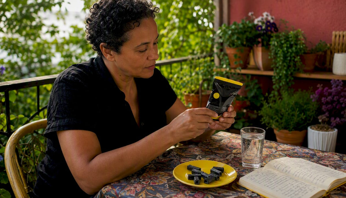 Person examining salmiak candy at kitchen table
