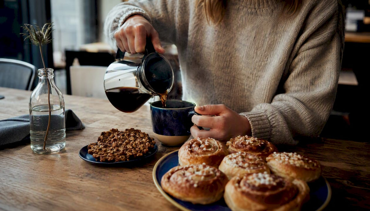 Pouring coffee over a plate of Swedish fika treats